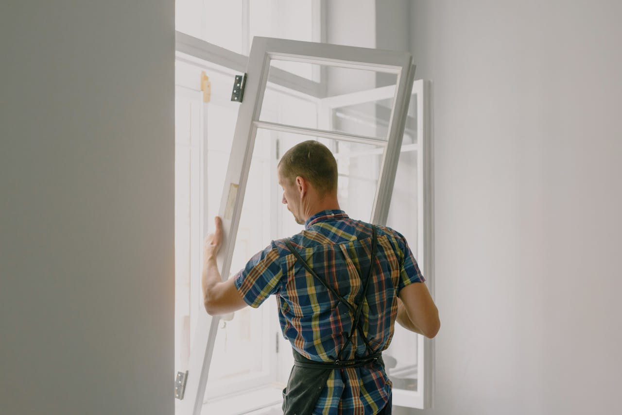 contact-img A professional installer fitting a modern window in a well-lit home interior.